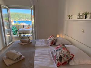 a bedroom with a large bed with pillows and a balcony at Apartments Poljak in Supetarska Draga +19 photos