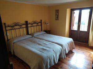 a bedroom with two beds and a sliding glass door at Casa Cebollero Autural in Fraginal