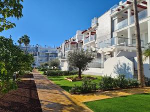 a row of white apartment buildings with palm trees at Casa Tumry in Denia