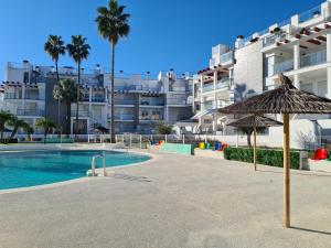 a swimming pool with an umbrella and a building at Casa Tumry in Denia