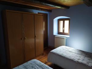 a bedroom with two beds and a cabinet and a window at Casa Cebollero Autural in Fraginal