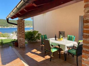 a dining room with a table and chairs on a patio at Apartments Poljak in Supetarska Draga