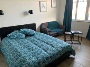 ein Schlafzimmer mit einem Bett, einem Sofa und einem Stuhl in der Unterkunft Gite les Combes Bellevue à Etrez, Appartement à la campagne in Étrez