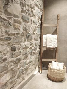 ein Badezimmer mit einer Steinwand mit einer Leiter und Handtüchern in der Unterkunft Landhaus im Allgäu in Halblech