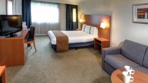 a hotel room with two beds and a television at Holiday Inn Maidstone-Sevenoaks, an IHG Hotel in Maidstone
