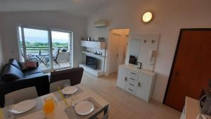 a living room with a couch and a table with chairs at Apartma Coccolo in Zambratija