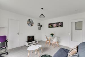 a living room with a couch and a table and chairs at Budget apart with balcony near Paris in Bondy