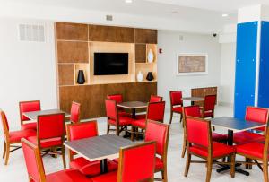 a dining room with tables and red chairs at Holiday Inn Express - Andalusia by IHG in Andalusia