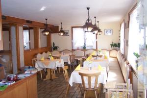 un restaurante con mesas y sillas blancas y ventanas en Gasthof Hotel Löwen, en Bad Buchau
