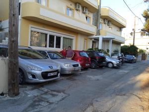 a row of cars parked in front of a building at La Santre Villa in Amoudara Herakliou