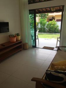 a living room with a sliding glass door to a patio at Privê Portal do Sol in Porto De Galinhas