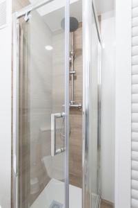 a shower with a glass door in a bathroom at Ático con espectacular terraza y vistas al mar in El Perelló