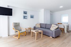 埃爾佩雷略的住宿－Ático con espectacular terraza y vistas al mar，客厅配有沙发、椅子和电视