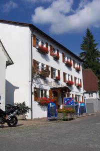 ein weißes Gebäude mit Blumenkästen an der Seite in der Unterkunft Gasthof Hotel Löwen in Bad Buchau