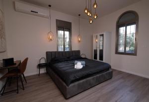 1 dormitorio con 1 cama, mesa y sillas en King's bed - Stay Royal and Stylish Bahai's Garden, en Haifa