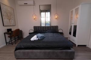 Un dormitorio con una cama con una toalla. en King's bed - Stay Royal and Stylish Bahai's Garden, en Haifa