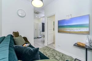 a living room with a couch and a tv on a wall at Tallinn City Harbour Apartments in Tallinn