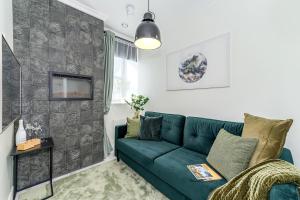 a living room with a green couch and a tv at Tallinn City Harbour Apartments in Tallinn