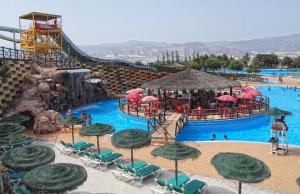 un parc aquatique avec un toboggan et une piscine avec des parasols dans l'établissement 5 bedrooms PRIVATE HOUSE 300M FROM BEACH, à Roquetas de Mar