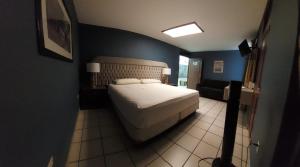 1 dormitorio con cama y pared azul en Hotel el Cortes, en Aguascalientes