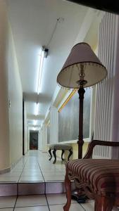 a hallway with a lamp and a bench in a building at Hotel el Cortes in Aguascalientes