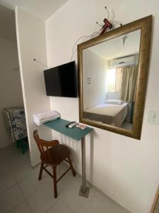 espejo en una habitación con mesa y cama en Pousada das Redes, en João Pessoa