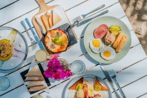 a table with plates of breakfast foods on it at Green Coast Beach Hotel in Punta Cana