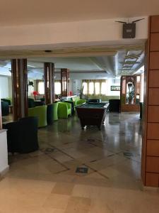 a lobby with a pool table and green chairs at Emira Hotel in Hammamet