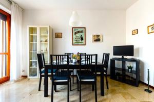 uma sala de jantar com uma mesa preta e cadeiras em Hostly - Family Home Cisanello em Pisa