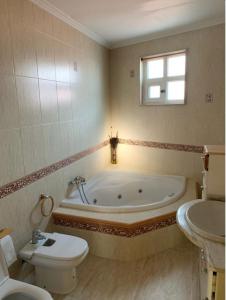ein Badezimmer mit einer Badewanne, einem WC und einem Waschbecken in der Unterkunft Casa da Moa in O Pindo