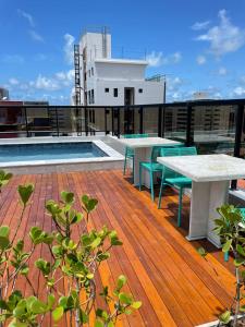 a rooftop deck with tables and a pool on a building at Hotel do Mar Tambaú in João Pessoa