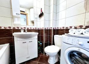 a bathroom with a toilet and a sink and a washing machine at Adriatique Apartments in Dobra Voda +7 photos