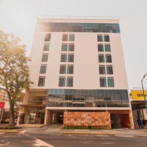 Un alto edificio bianco con un cartello davanti di Hotel Klimt a Xalapa