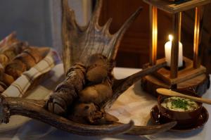 una mesa con una pieza central de cuernos de ciervo y una vela en Bear Manor B&B en Kannonkoski