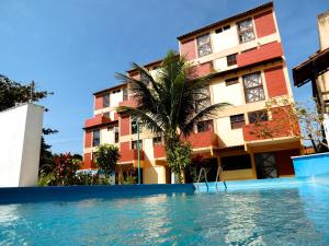 ein Hotel mit einem Pool vor einem Gebäude in der Unterkunft Apart-Hotel Marinas da Lagoa - 2 Praias a 4 Min - in Saquarema