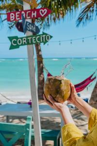 a person holding a coconut in front of a beach at Green Coast Beach Hotel in Punta Cana