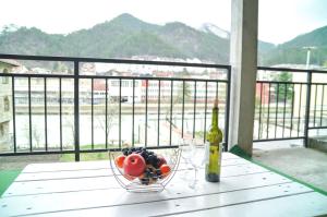 a bowl of fruit and a bottle of wine on a table at Apartment Dino in Konjic