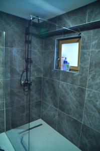 a bathroom with a shower with a toilet and a window at Apartment Dino in Konjic +6 photos