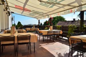 restauracja ze stołami i krzesłami pod baldachimem w obiekcie Hotel Panorama w Pilznie