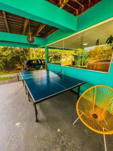 a ping pong table and a chair in a room at Pousada Orquídeas do Guarujá in Guarujá