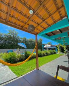 a hammock under a pergola in a patio at Pousada Orquídeas do Guarujá in Guarujá