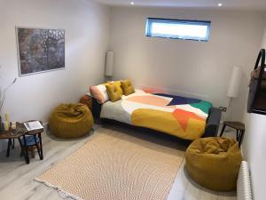 1 dormitorio con 1 cama y 2 reposapiés en The Den - your cosy sleepover space, en St Fillans