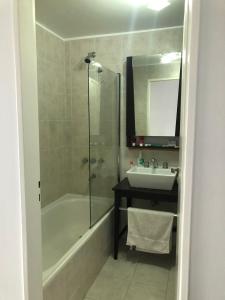 een badkamer met een douche, een wastafel en een bad bij El Descanso - Ushuaia in Ushuaia