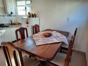 una cucina con tavolo in legno, sedie e frigorifero bianco di Nothofagus a Caviahue
