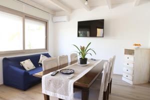 a dining room with a table and a blue couch at Capri 53 in Àrbatax