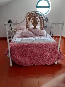un letto in una stanza con una coperta rosa sopra di Monte Geralda a Cercal