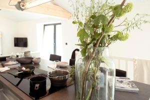 a vase filled with flowers on a kitchen counter at Appartementen Zer en Loft in centrum Bergen in Bergen