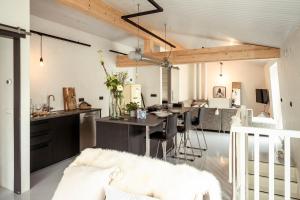 a living room with a white couch and a kitchen at Appartementen Zer en Loft in centrum Bergen in Bergen