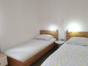 a bedroom with two beds and a nightstand and a bed sidx sidx sidx sidx at Apartment Antonia in Šibenik