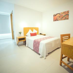 a bedroom with a bed and a table and a desk at Hotel Klimt in Xalapa